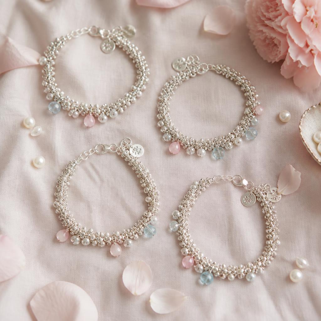 A flat lay of handmade silver cluster bracelets with pink and blue accents